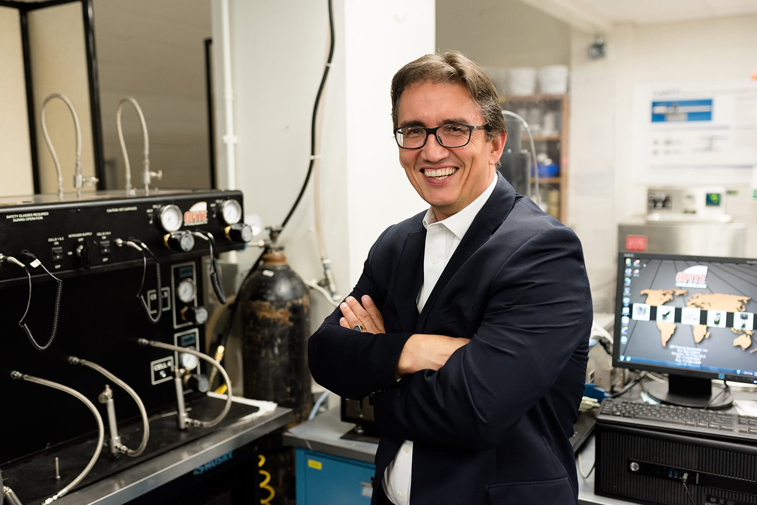 Eric van Oort smiling in lab with arms crossed.