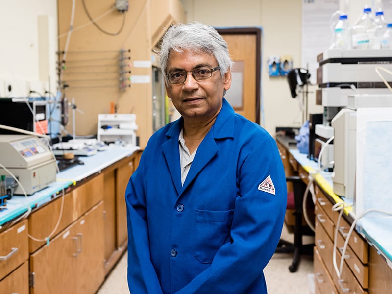 Kishore Mohanty standing in lab wearing lab coat.