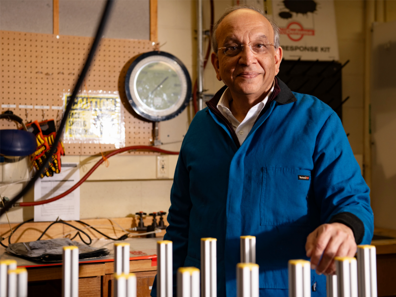 Mukul Sharma smiling in research lab next to tables of equipment.