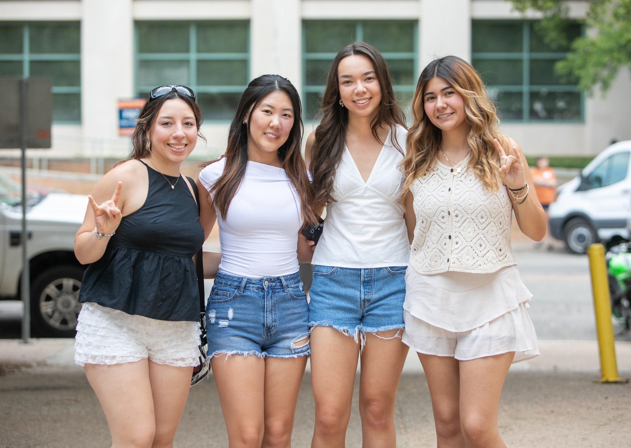 PGE students smiling in a group and doing hook 'em horns hand signs.