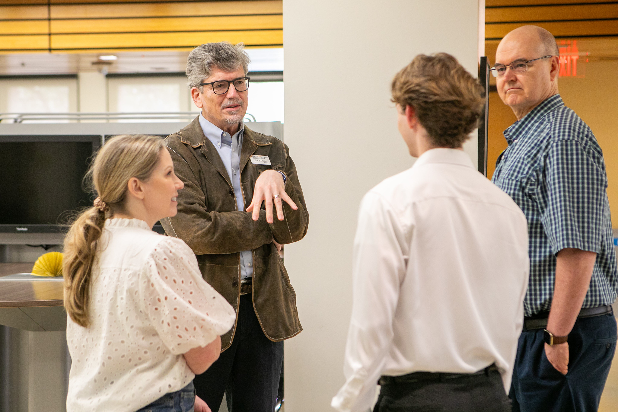 Professor emeritus Jon Olson talking to small group of faculty and students.