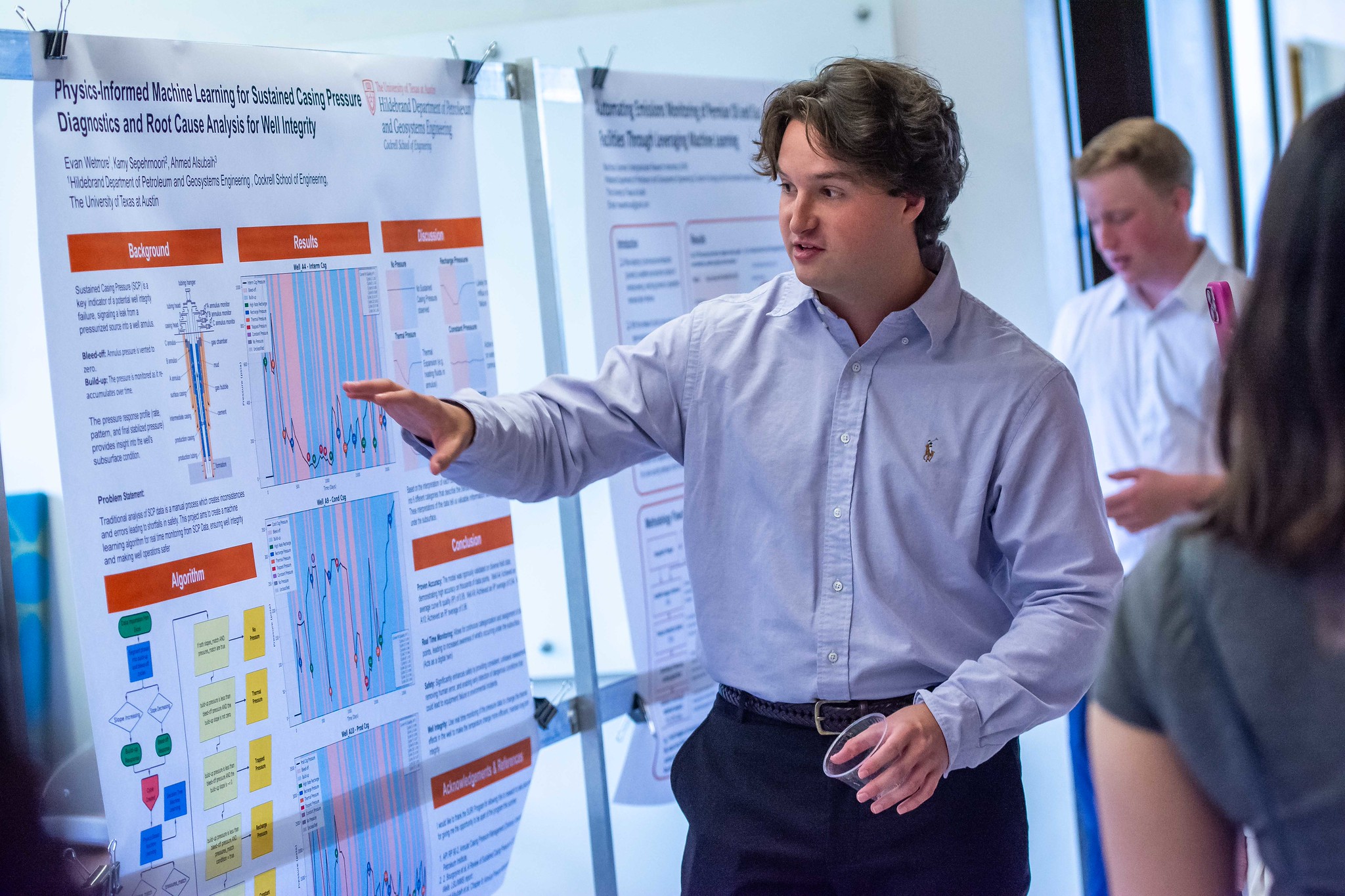 PGE student pointing to research poster as they discuss research with onlookers.