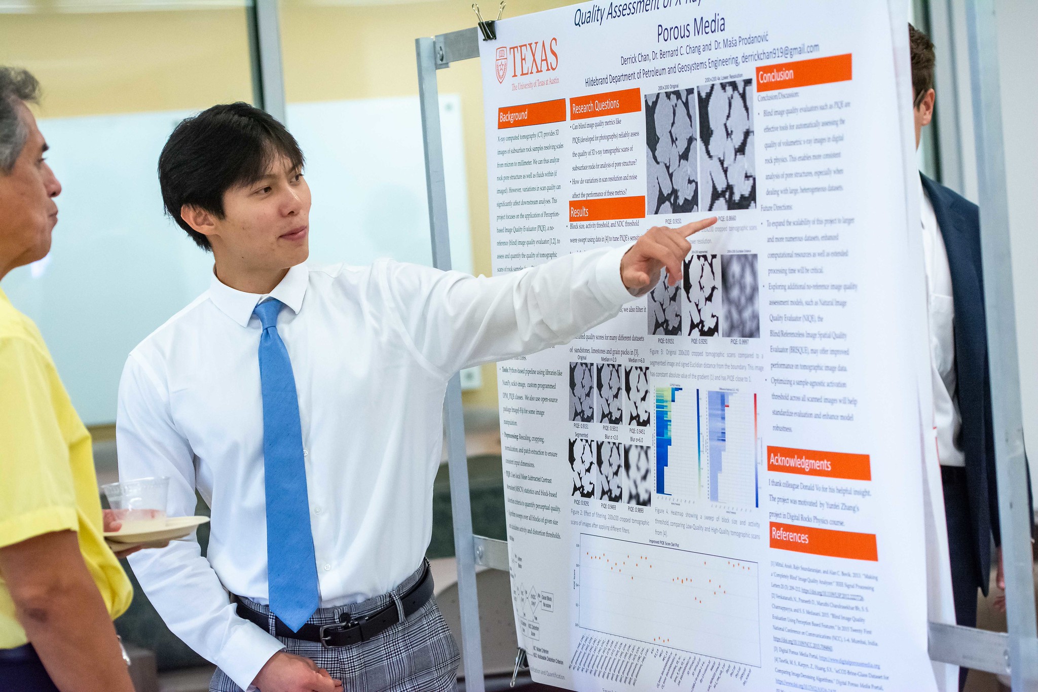 PGE student gesturing to research poster while talking to crowd.