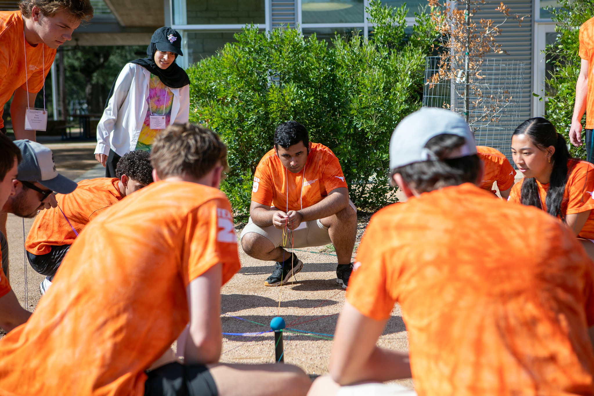 PGE students gathered around activity on ground outside during First-Year Fall Retreat event.