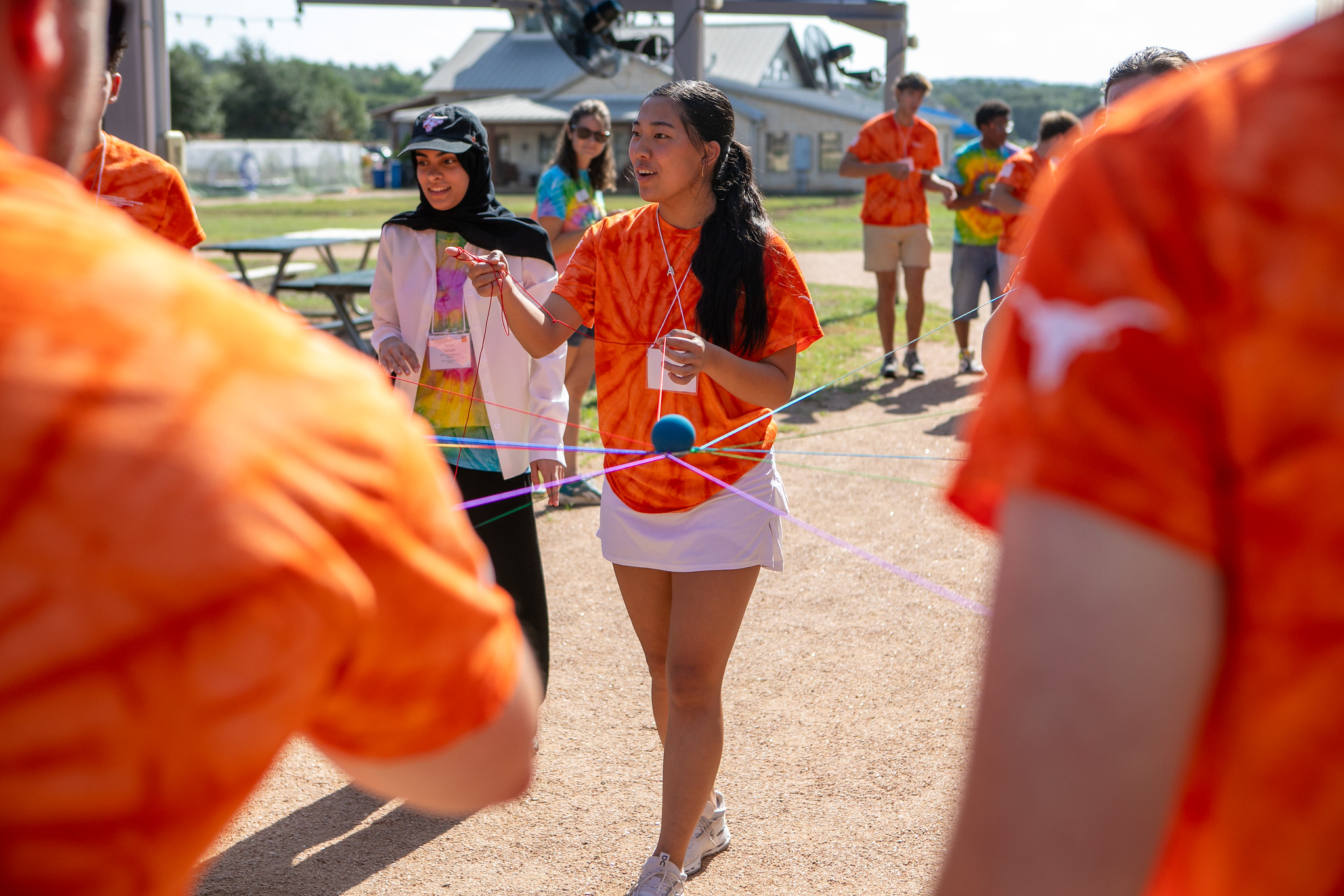 UT PGE students playing game with string outside during First-Year Fall Retreat event.