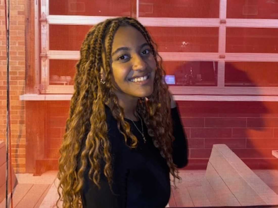 UT PGE student Brooke Franklin smiling in front of brick wall.